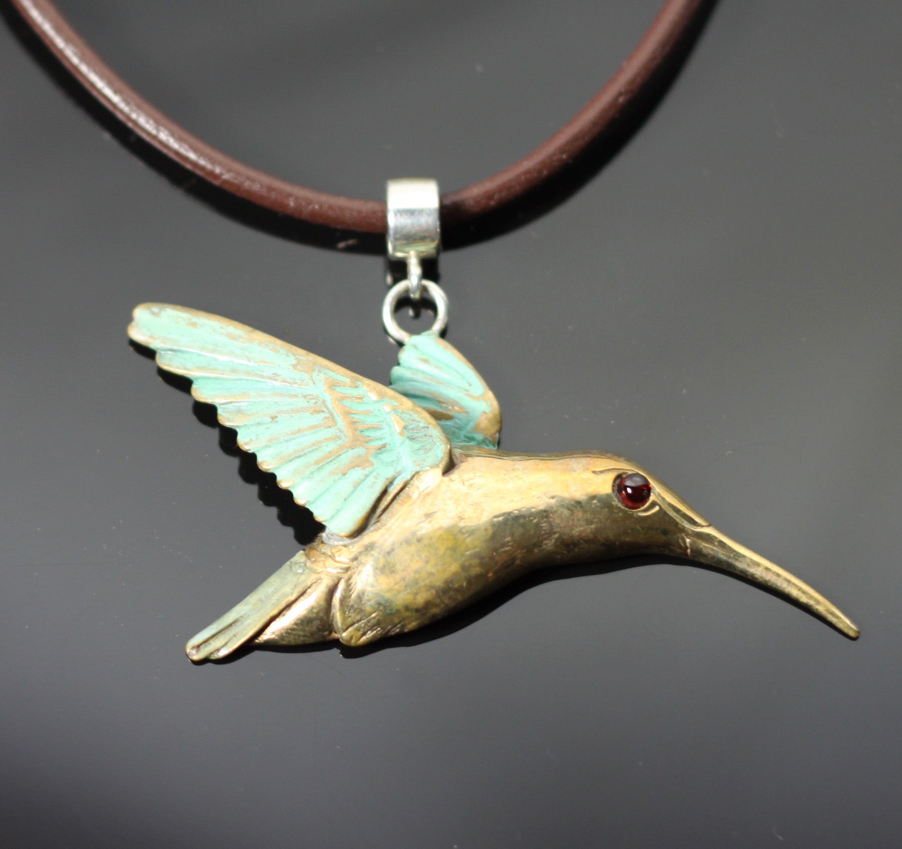 Bronze Hummingbird Pendant with Garnet Eye by Anisa Jewelry
