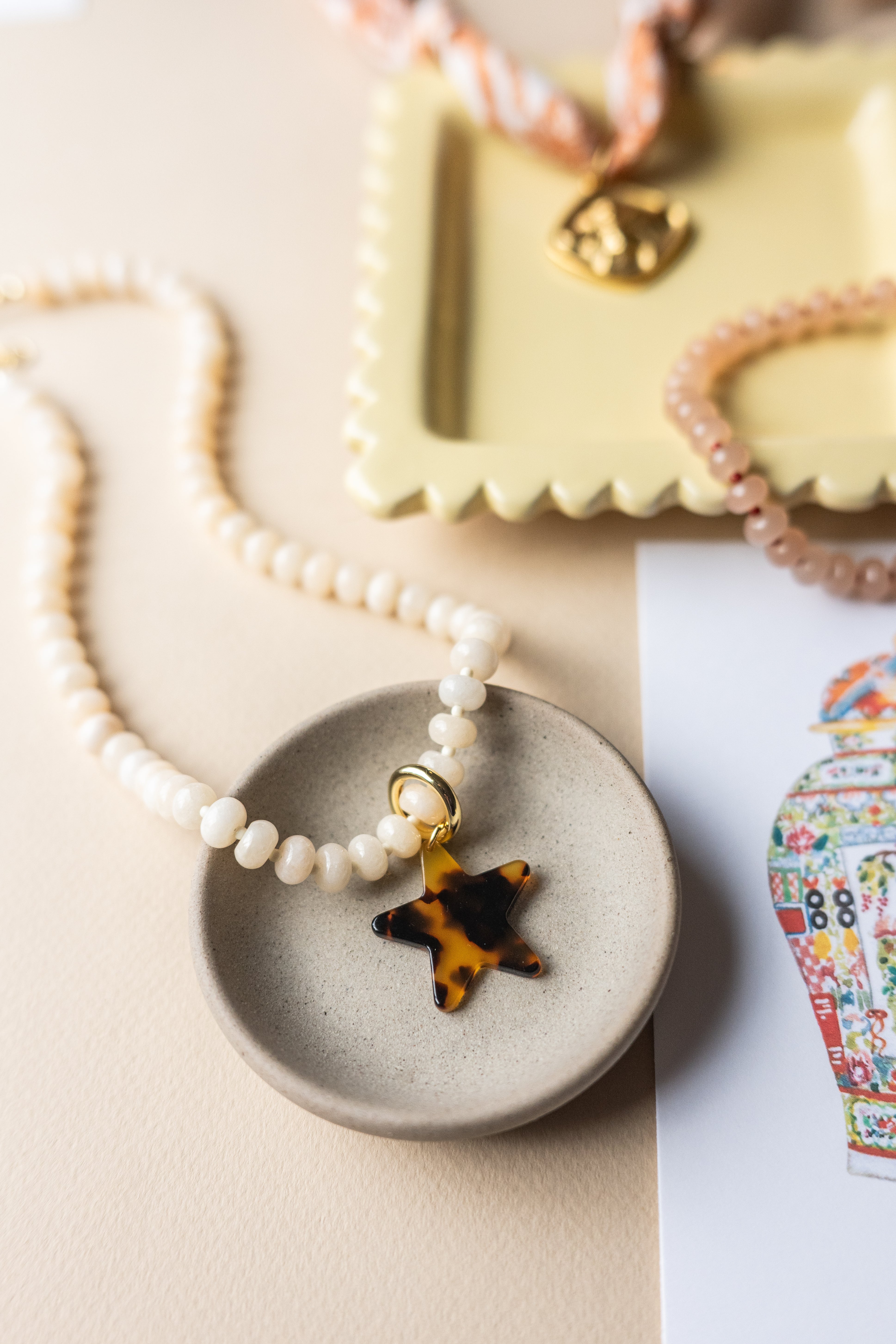 The Cleo Beige Beaded Star Charm Necklace detail view by London Crafted