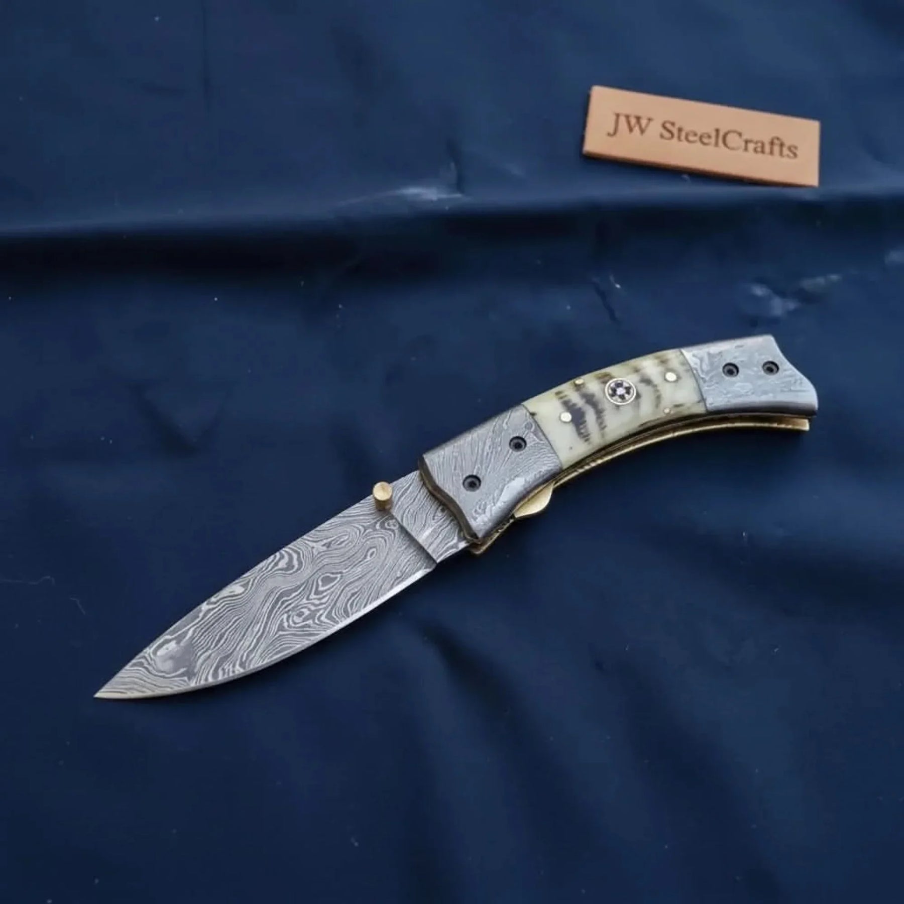 Swayback Damascus folding knife with bone handle and Damascus bolster caps