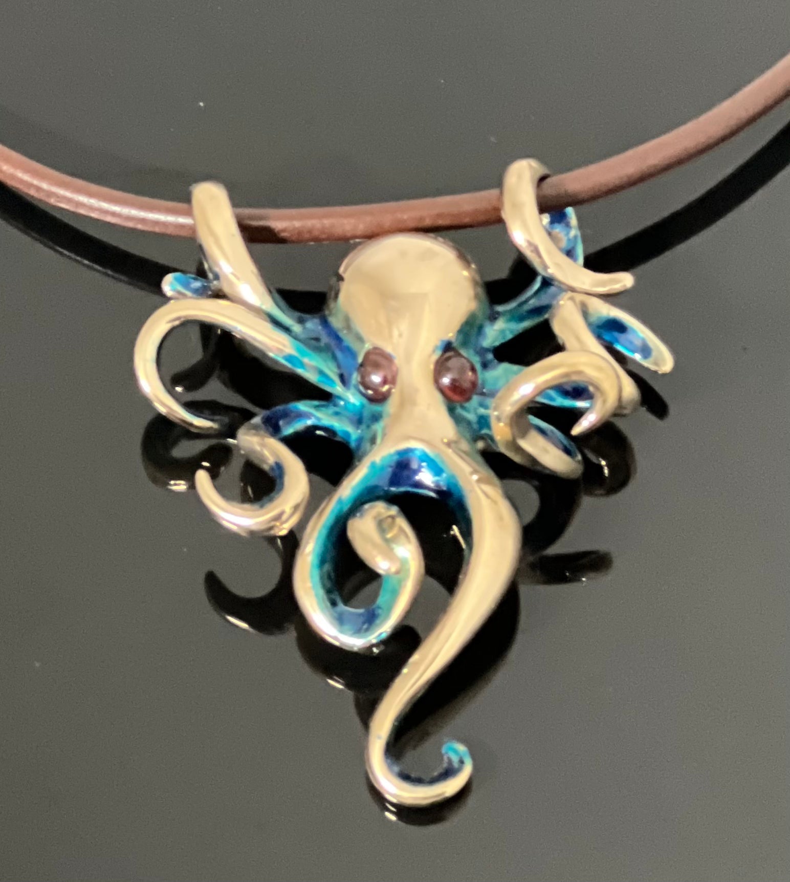 Bronze Octopus Pendant with Blue Patina and Garnet Eyes by Anisa Jewelry